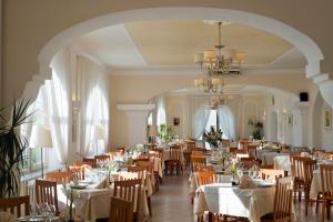 a dining room with tables and chairs and a chandelier at Casa Di Meglio Dependance in Ischia