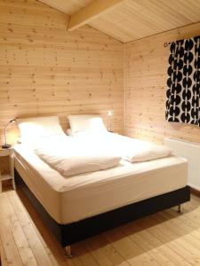 a bedroom with a bed in a wooden wall at Midholl guesthouse in Ásmundarstaðir