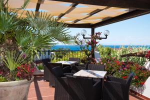 un patio con mesas, sillas y flores en Casa Di Meglio Dependance en Isquia