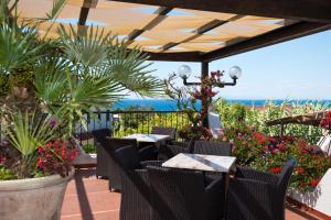 a patio with tables and chairs and flowers at Casa Di Meglio Dependance in Ischia