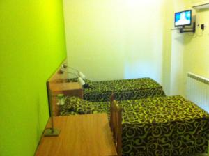 a room with two beds and a table with a mirror at Hostal Neptuno in Cáceres