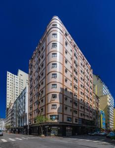 a tall building on a city street at Real Castilha Hotel in Sao Paulo