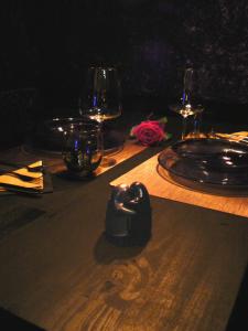 
a table topped with a glass of wine and a candle at Le Cocon Enchanteur in Plélan-le-Grand
