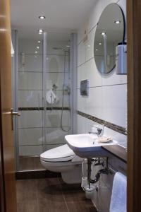 a bathroom with a shower and a toilet and a sink at Hotel Krone in Pfullendorf
