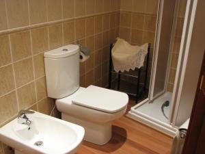 a bathroom with a toilet a sink and a bathtub at Aparthotel Santa Marina in Cuéllar