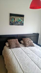 ベニカルロにあるDuplex Apartamentoのベッド1台(枕2つ、上部に赤いランプ付)
