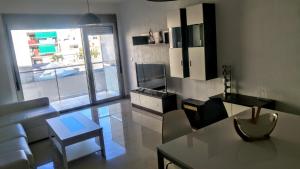 ベニカルロにあるDuplex Apartamentoのリビングルーム(ソファ、テーブル付)、キッチンが備わります。