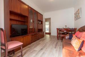 ein Wohnzimmer mit einem Flachbild-TV und einem Sofa in der Unterkunft Rato Deluxe by Homing in Lissabon