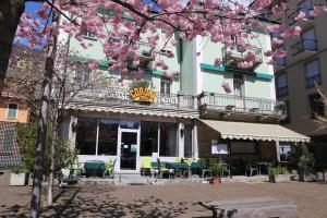 un edificio con fiori rosa su un albero di Hotel Corona a Locarno