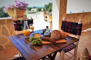 a wooden table with food and drinks on it at Siamoformentera Donatella in San Ferrán de ses Roques