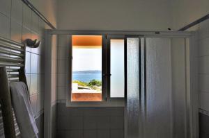 a bathroom with a window with a view of the ocean at Siamoformentera Donatella in Sant Ferran de Ses Roques