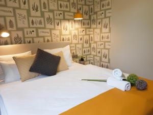 a bedroom with a white bed with towels on it at Ditlin in Pápa