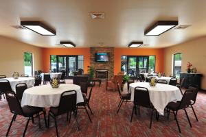a banquet hall with tables and chairs and a fireplace at Sunset Bay Resort & Suites in Wisconsin Dells