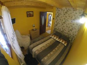 una piccola camera da letto con un letto e uno specchio di Cabana FARIO Rau Mare - Retezat a Clopotiva