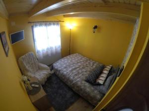 una piccola camera da letto con un letto e una sedia di Cabana FARIO Rau Mare - Retezat a Clopotiva Altre 10 foto