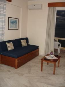 a living room with a blue couch and a table at Nea Elena Apartments in Chania