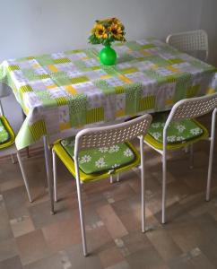 una mesa con dos sillas y un jarrón de flores. en APP Veselica, en Umag