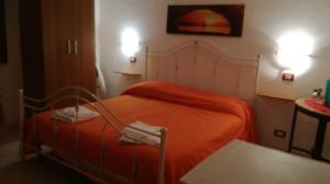 a bedroom with a bed with an orange blanket at Casa San Liberale in Trapani