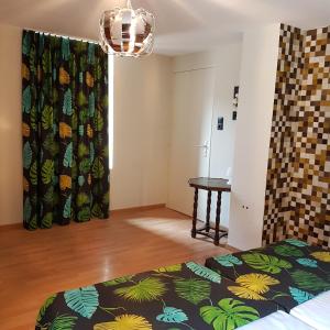 ein Schlafzimmer mit einem Bett und einem Tisch in einem Zimmer in der Unterkunft Alsace Randonnee ou Ski Bel appartement in Grendelbruch