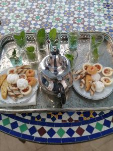 a table with two plates of food and a tea kettle at dar wassim el ghali in Rabat