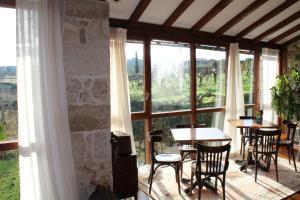 a room with tables and chairs and a large window at Rectoral de Anllo in Sober +105 photos