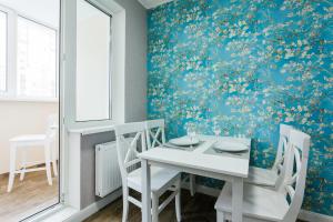 a dining room with a white table and chairs at Cosy Apartment at Pozniaky in Kyiv