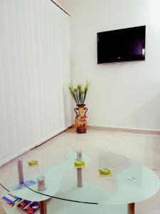 um quarto branco com uma mesa de vidro e uma televisão em Apartman Milovic em Tivat