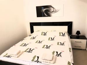 a bedroom with a bed with black and white sheets at Apartman Milovic in Tivat