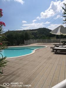 basen z drewnianym tarasem i parasolem w obiekcie Country house "L'isola che non c'è" w mieście Ancona