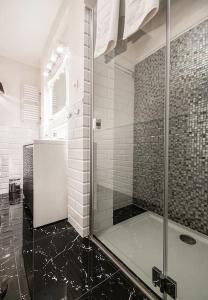 a shower with a glass door in a bathroom at Elegant Apartment Foksal in Warsaw