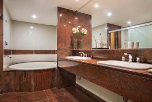 a bathroom with two sinks and a large mirror at Royal Rio Palace Hotel in Rio de Janeiro