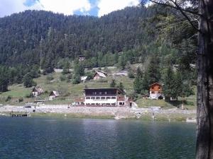 una casa sentada a un lado de un lago en Grand Chalet Du Lac Du Boreon, en Saint-Martin-Vésubie