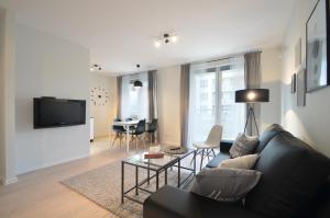 ein Wohnzimmer mit Sofa und Tisch in der Unterkunft Apartamenty-Plaza Kołobrzeg in Kołobrzeg