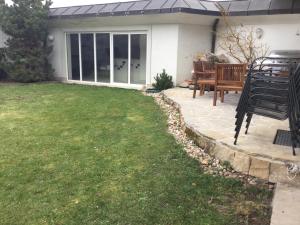 a patio with a bench and a grass yard at Justyna in Pardubice