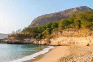 a sandy beach with a mountain in the background at Casa Mendes in Tarrafal