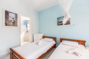 two beds in a room with blue walls at Romanza in Cherronisos