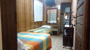 Habitación de hotel con 2 camas y ventana en Candy Ilhabela 1, en Ilhabela