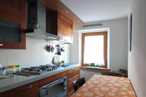 eine Küche mit einem Herd und einem Tisch darin in der Unterkunft Appartamenti dolomitici in Padola