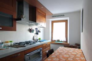 a kitchen with a stove and a table in it at Appartamenti dolomitici in Padola