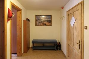 une chambre avec un banc et un tableau sur le mur dans l'établissement Appartamenti dolomitici, à Padola
