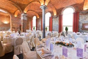 a banquet hall with white tables and chairs at Aparthotel Le Manoir du Capitaine in Feluy