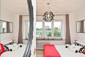 ein Schlafzimmer mit einem Spiegel und einem Bett mit einem roten Teppich in der Unterkunft WSTApartments Młynarska 13 in Warschau