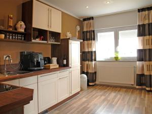 a kitchen with white cabinets and a window at NM-APARTMENTS in Griesheim +7 photos