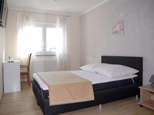 a bedroom with a bed and a window at NM-APARTMENTS in Griesheim