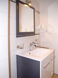 a bathroom with a white sink and a mirror at NM-APARTMENTS in Griesheim
