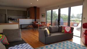 a living room with a couch and a kitchen at SeymourViews Apollo Bay in Apollo Bay