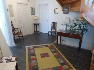 sala de estar con mesa y alfombra en el suelo en Forgefield House, en Kenmare