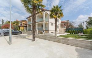 a car parked in front of a house with palm trees at Villa Stephany in Poreč