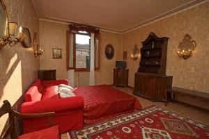 a bedroom with a red bed and a red couch at Ca Barbaro with altana-appartamenti storici- in Venice