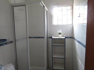un bagno con doccia e porta a vetri di Cabañas Antilhue a Olmué